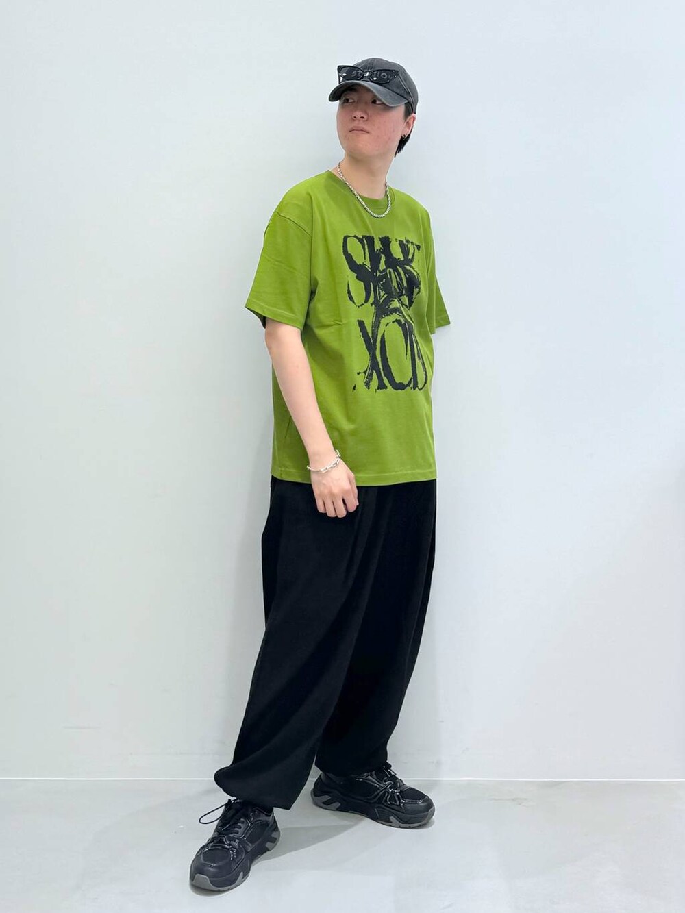 ブラック系のスウェットパンツ、グリーン系のTシャツ/カットソー、グレー系のキャップを着用したメンズの夏コーディネートの3枚目の写真