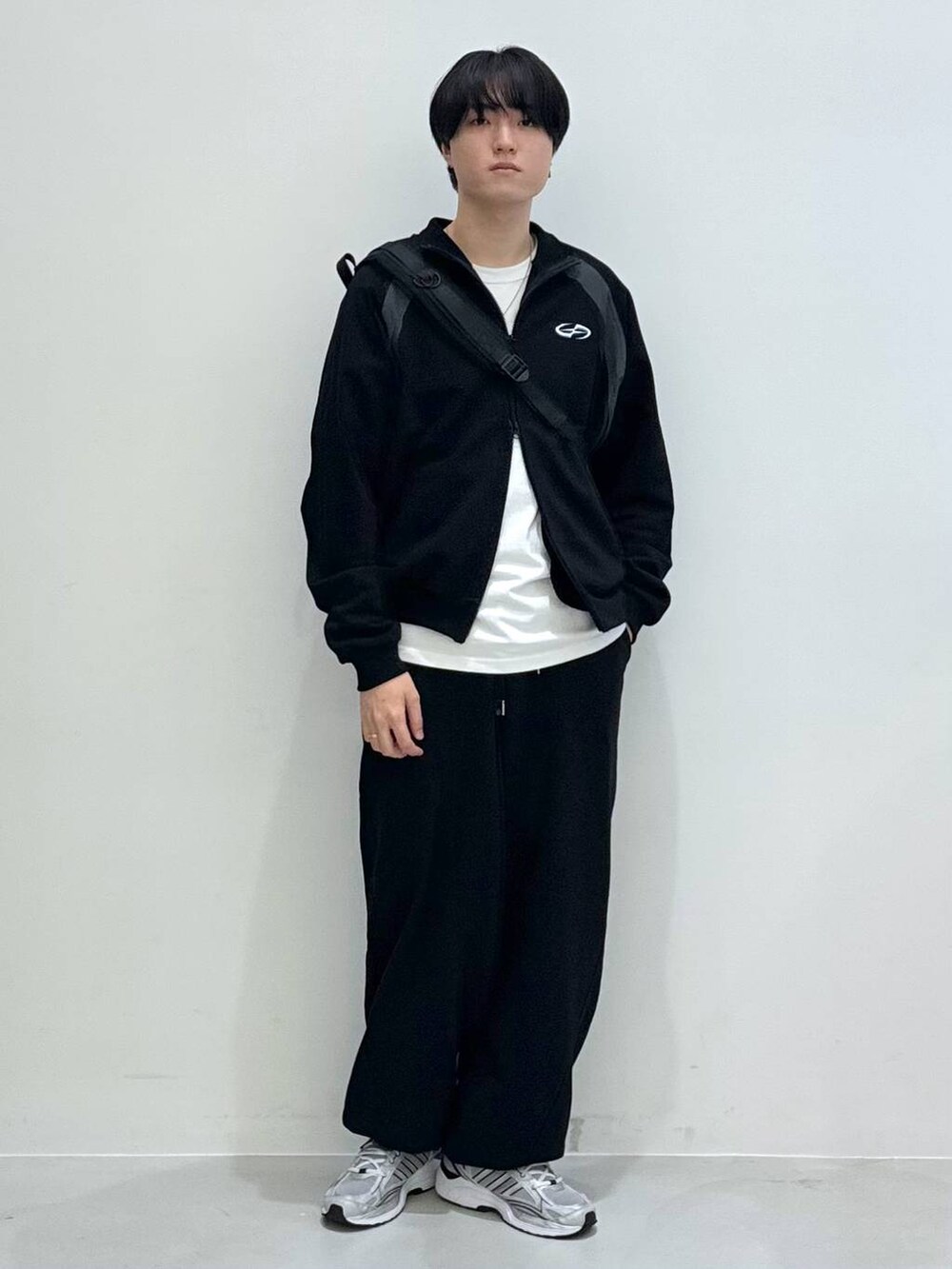 ブラック系のバックパック/リュック、ブラック系のスウェットパンツ、ホワイト系のTシャツ/カットソーを着用したメンズの冬コーディネートの6枚目の写真