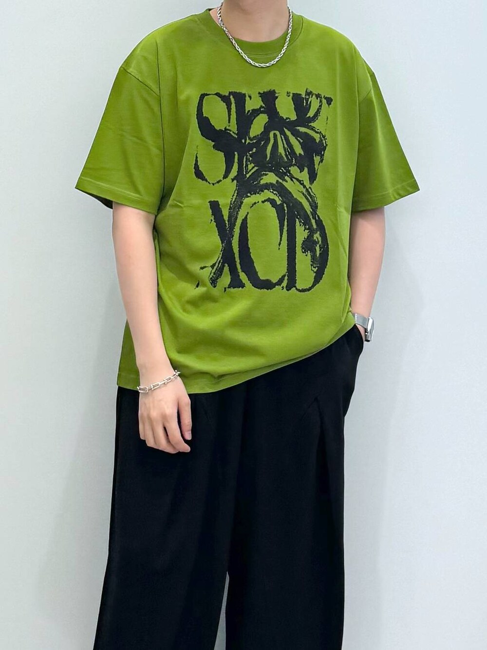 ブラック系のスウェットパンツ、グリーン系のTシャツ/カットソー、グレー系のキャップを着用したメンズの夏コーディネートの2枚目の写真