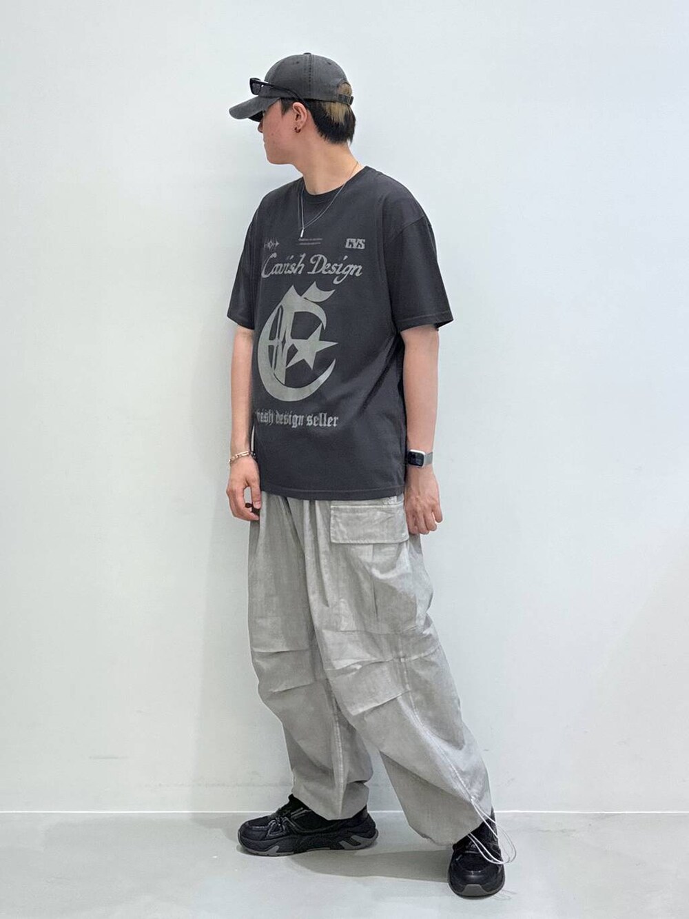 グレー系のTシャツ/カットソー、グレー系のキャップ、ブラック系のサングラスを着用したメンズの夏コーディネートの3枚目の写真