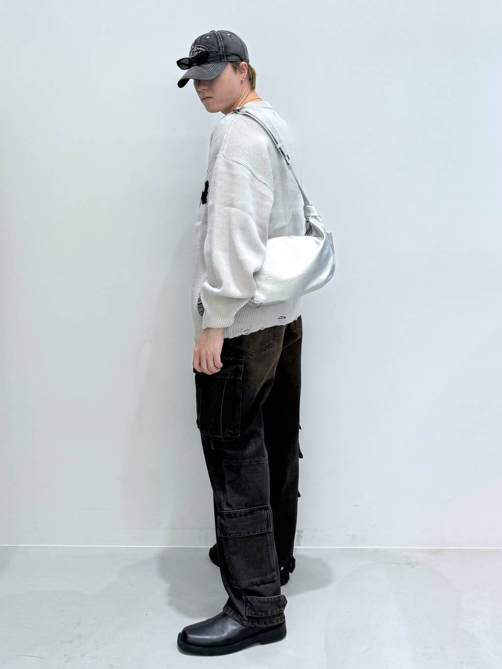 ブラック系のブーツ、ブラック系のデニムパンツ、その他のショルダーバッグを着用したメンズの秋コーディネートの3枚目の写真