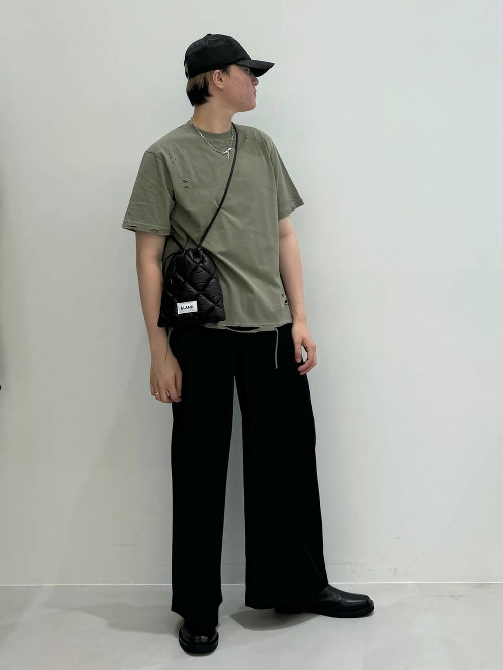 ブラック系のブーツ、ブラック系のショルダーバッグ、ブラック系のスラックスを着用したメンズの夏コーディネートの5枚目の写真