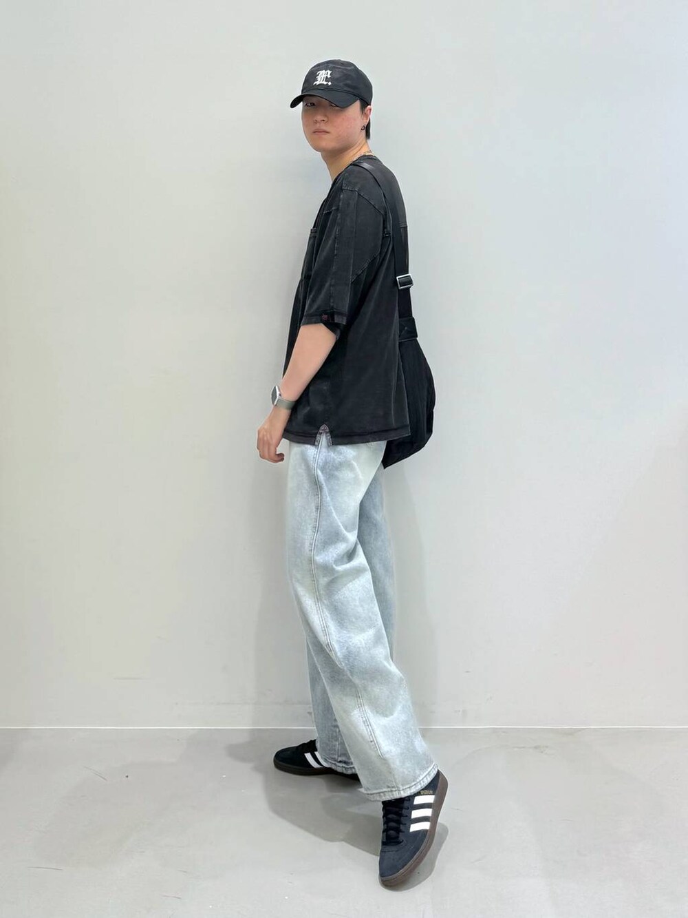 ブルー系のデニムパンツ、ブラック系のショルダーバッグ、ブラック系のスニーカーを着用したメンズの夏コーディネートの2枚目の写真