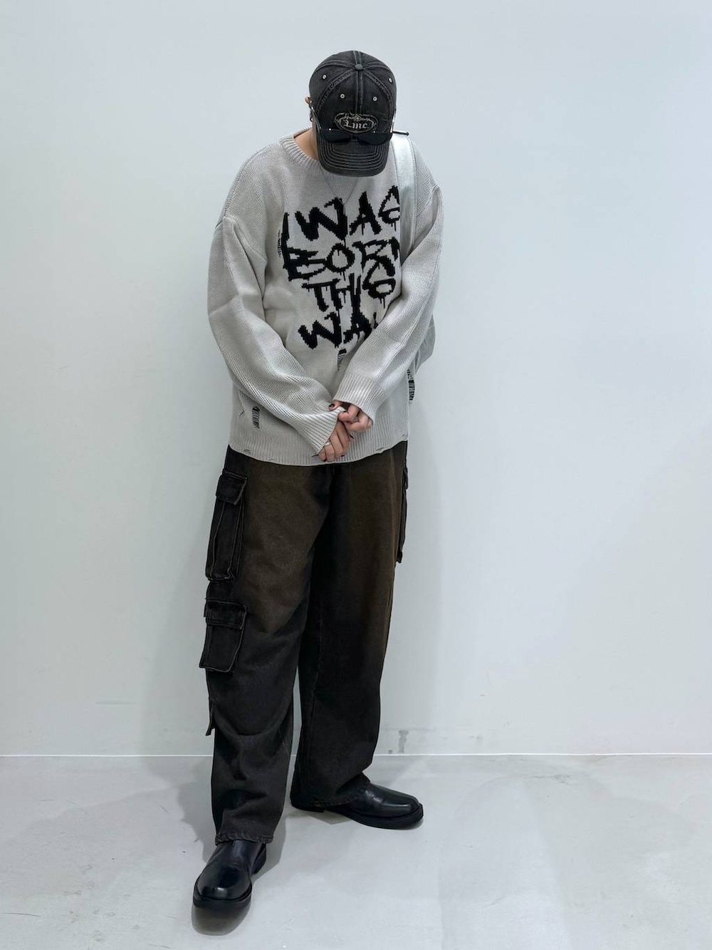 ブラック系のブーツ、ブラック系のデニムパンツ、その他のショルダーバッグを着用したメンズの秋コーディネートの7枚目の写真