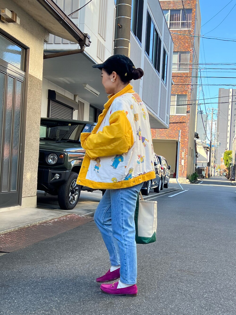 ブルー系のデニムパンツ、ピンク系のローファー、グリーン系のトートバッグを着用したレディースの冬コーディネートの3枚目の写真