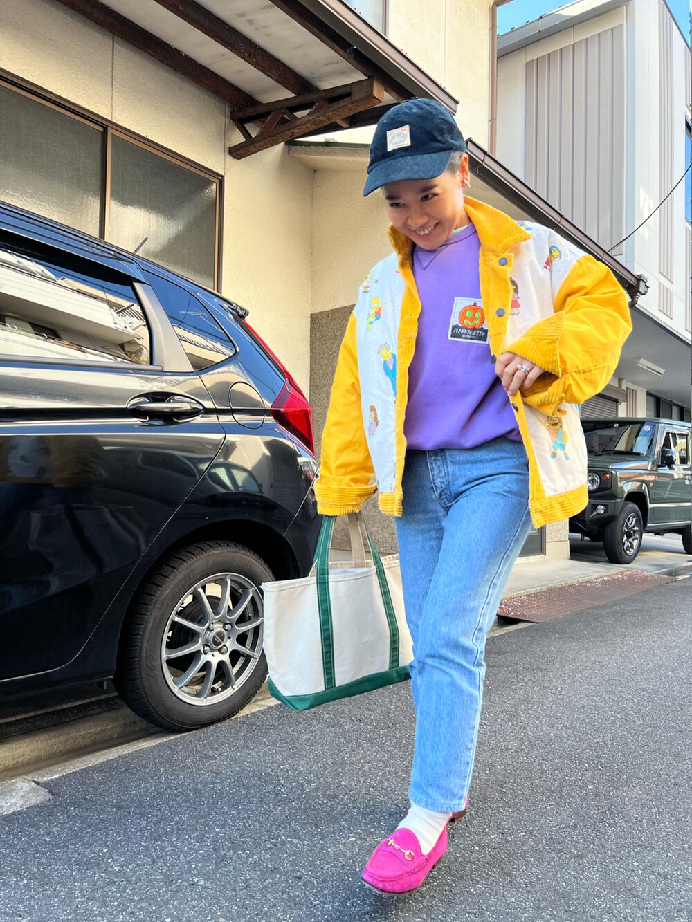 ブルー系のデニムパンツ、ピンク系のローファー、グリーン系のトートバッグを着用したレディースの冬コーディネートの2枚目の写真