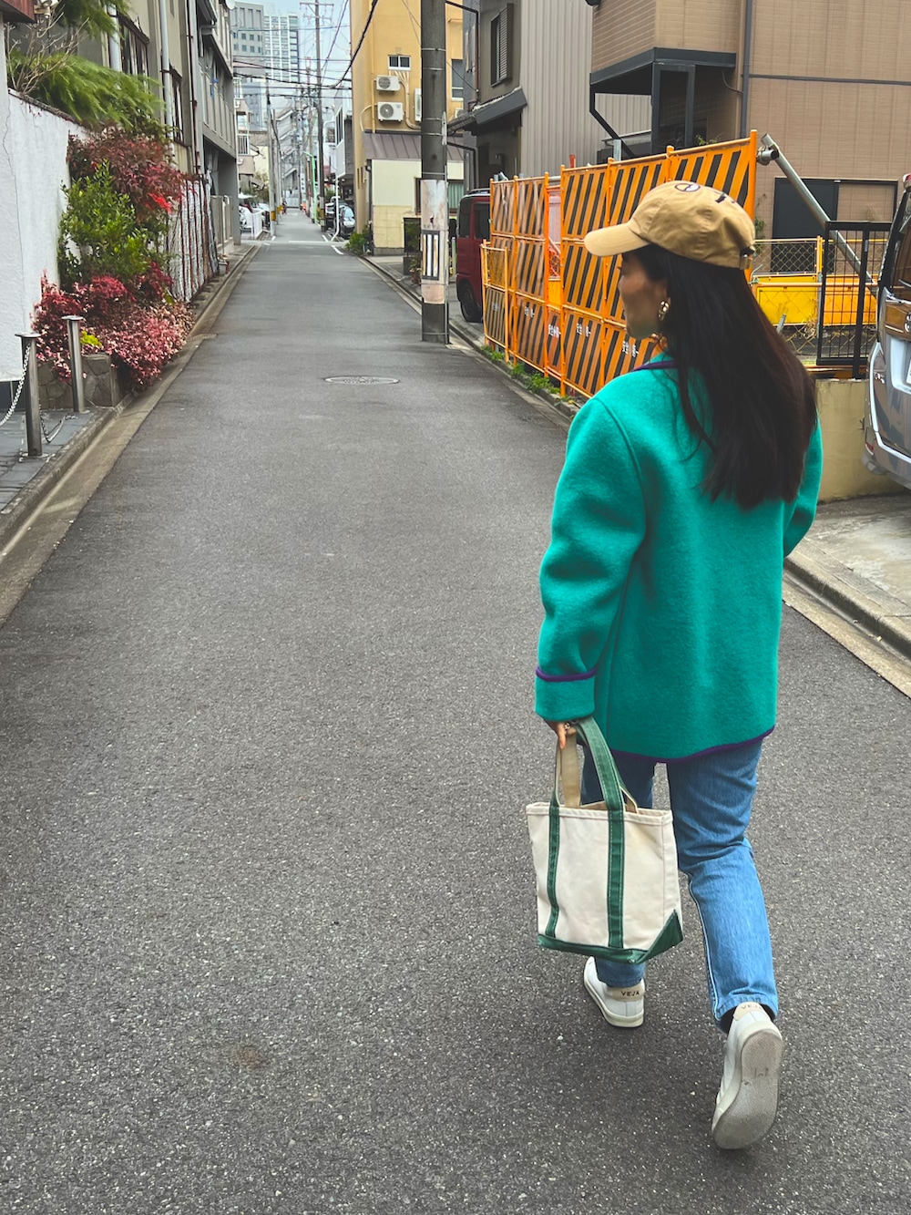 グリーン系のトートバッグ、グレー系のスウェット、ホワイト系のスニーカーを着用したレディースの冬コーディネートの2枚目の写真