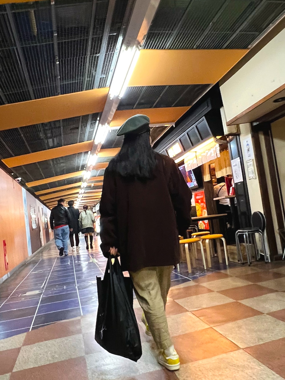 ホワイト系のジャージ、ベージュ系のチノパンツ、イエロー系のスニーカーを着用したレディースの春コーディネートの4枚目の写真