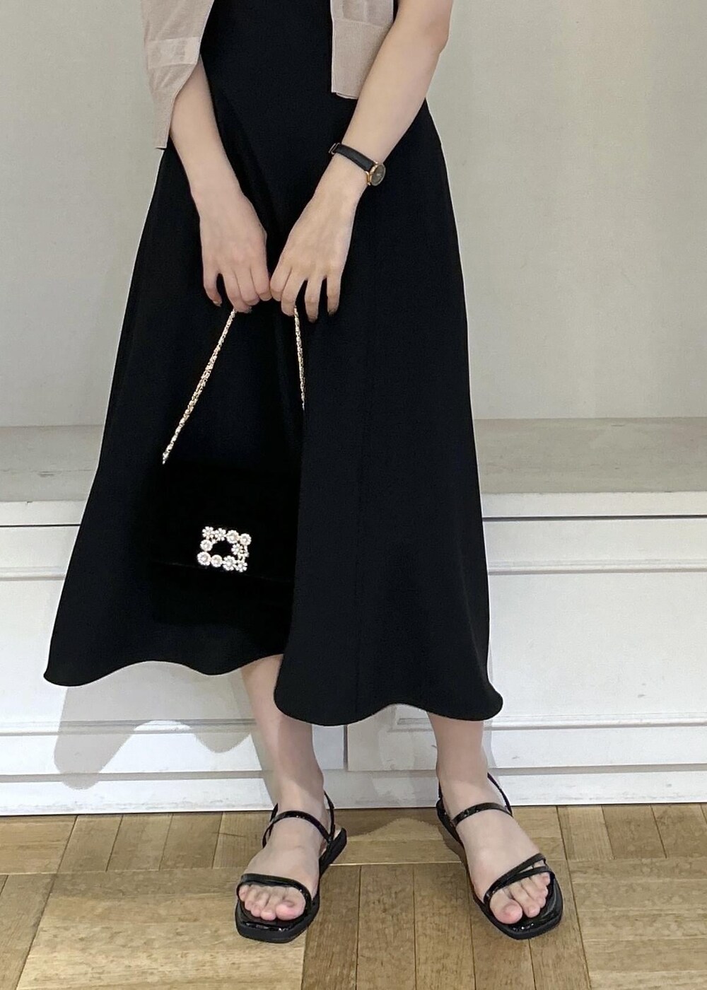 ブラック系のドレス、ブラック系のショルダーバッグ、ベージュ系のカーディガン/ボレロを着用したレディースの夏コーディネートの5枚目の写真