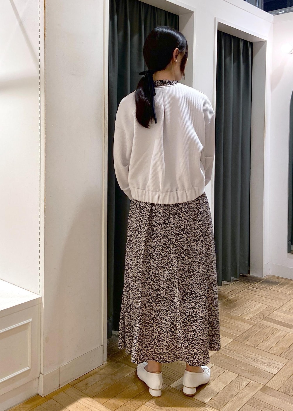ブルー系のハンドバッグ、ホワイト系のパンプス、グレー系のブルゾンを着用したレディースの春コーディネートの5枚目の写真