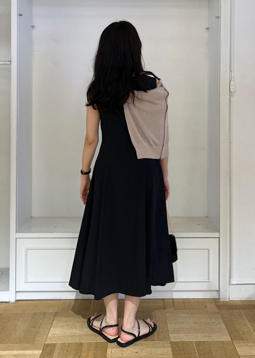 ブラック系のドレス、ブラック系のショルダーバッグ、ベージュ系のカーディガン/ボレロを着用したレディースの夏コーディネートの4枚目の写真