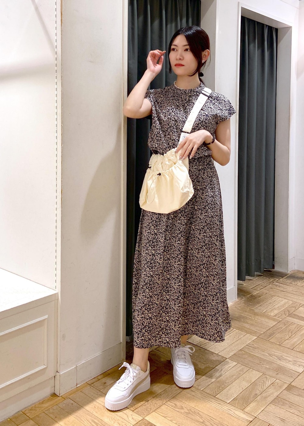 ブルー系のハンドバッグ、ホワイト系のパンプス、グレー系のブルゾンを着用したレディースの春コーディネートの6枚目の写真