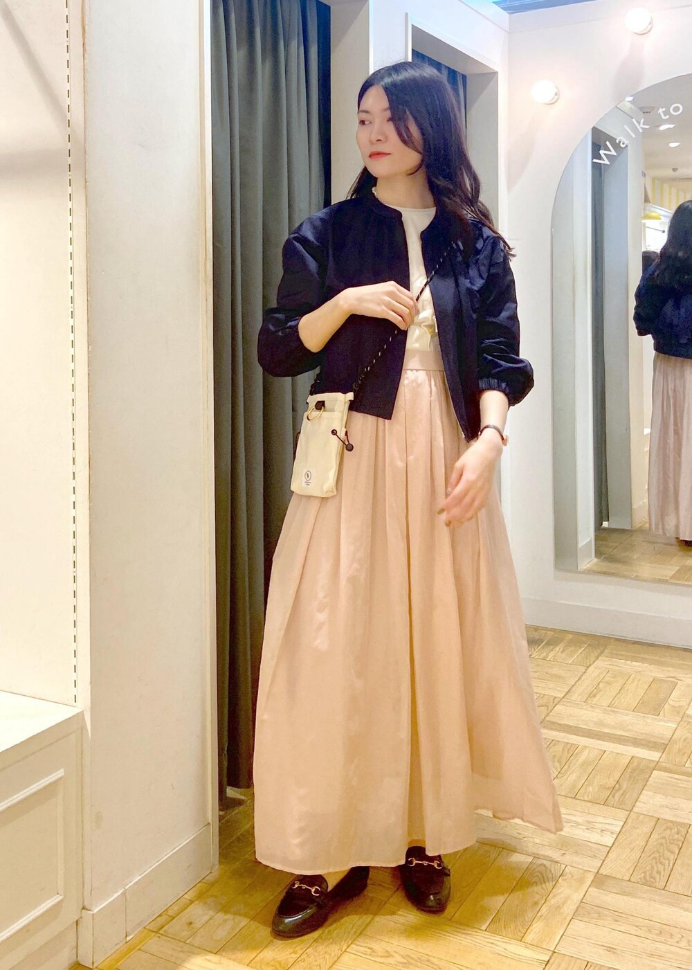 ブラック系のローファー、ピンク系のスカート、ブルー系のブルゾンを着用したレディースの春コーディネートの2枚目の写真