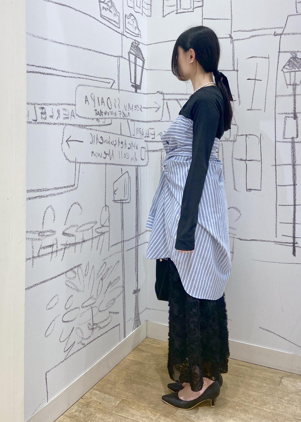 ブラック系のパンプス、ブラック系のTシャツ/カットソー、ブラック系のトートバッグを着用したレディースの春コーディネートの3枚目の写真