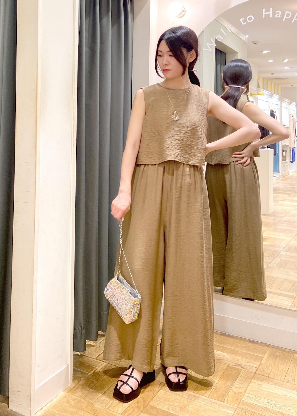 グレー系のショルダーバッグ、ブラック系のサンダル、グリーン系のつなぎ/オールインワンを着用したレディースの夏コーディネートの2枚目の写真