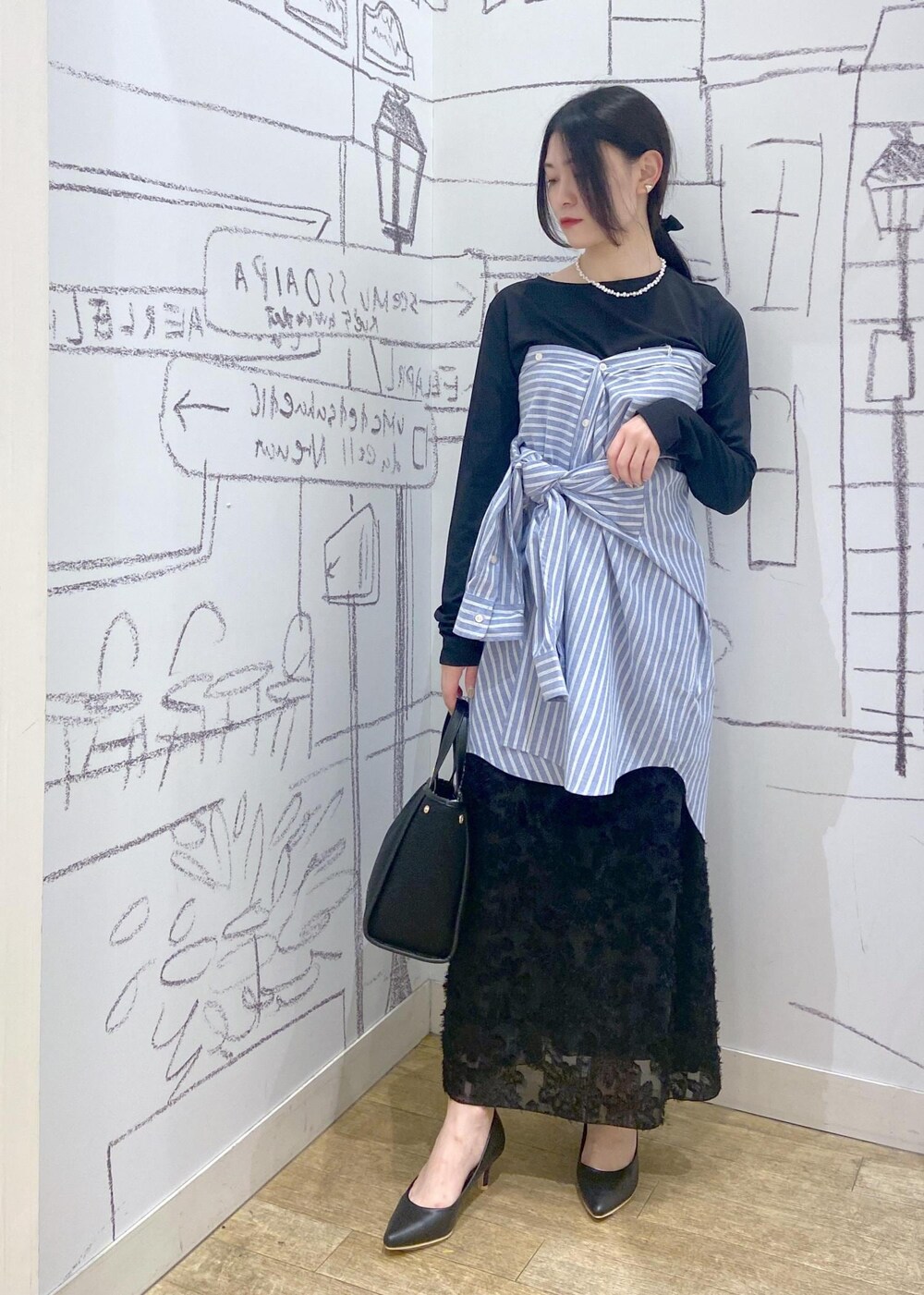 ブラック系のパンプス、ブラック系のTシャツ/カットソー、ブラック系のトートバッグを着用したレディースの春コーディネートの2枚目の写真