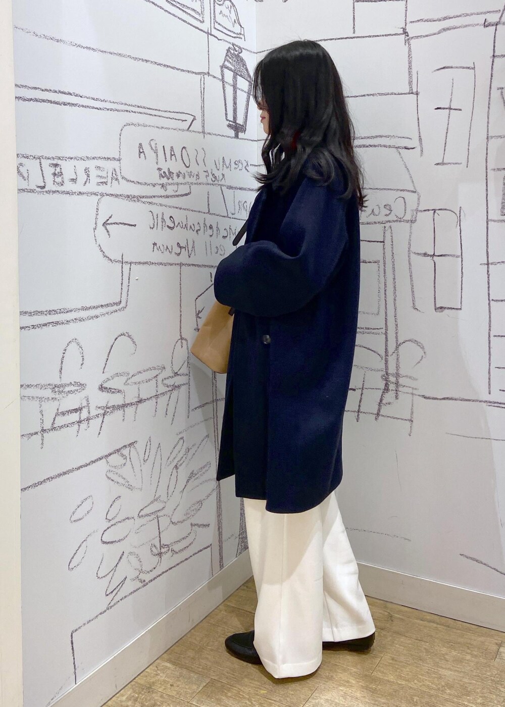 レッド系のTシャツ/カットソー、ブラック系のローファー、ブルー系のピーコートを着用したレディースの冬コーディネートの3枚目の写真