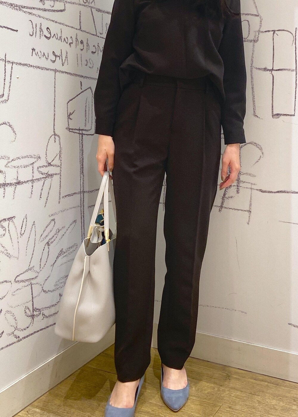 ブラック系のシャツ/ブラウス、ブルー系のパンプス、グレー系のトートバッグを着用したレディースの冬コーディネートの4枚目の写真