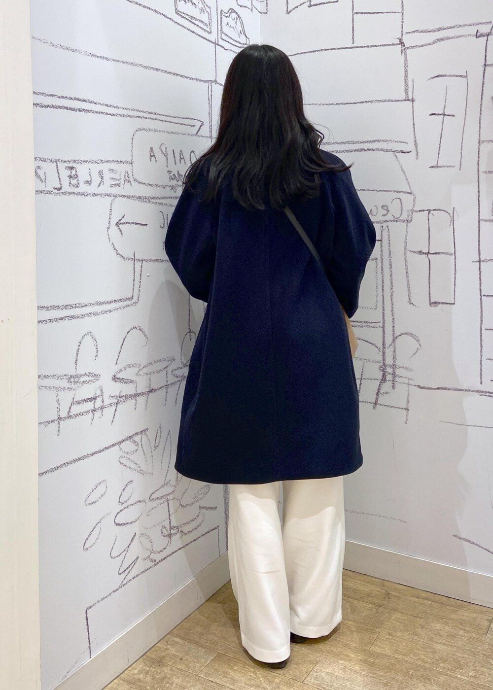 レッド系のTシャツ/カットソー、ブラック系のローファー、ブルー系のピーコートを着用したレディースの冬コーディネートの4枚目の写真