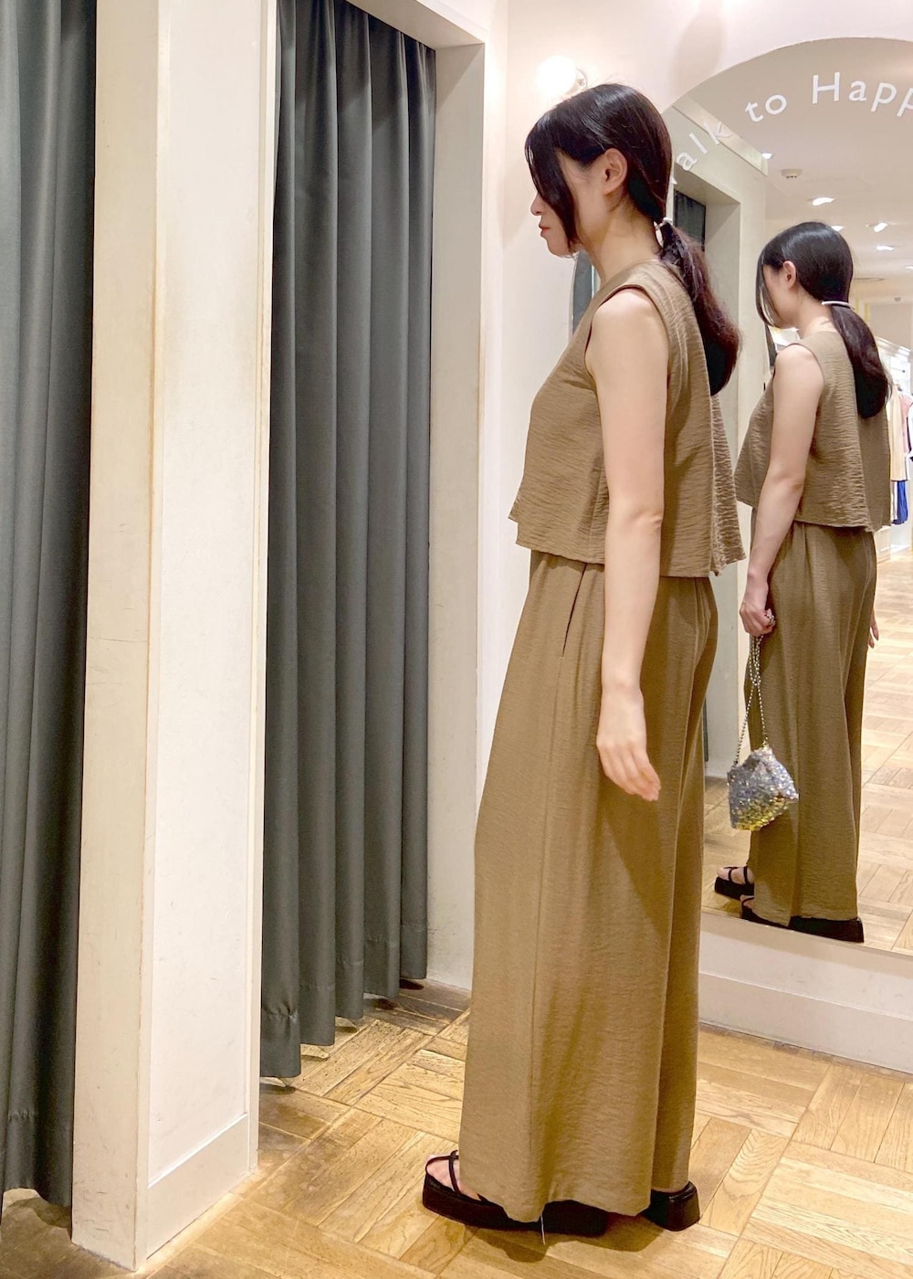 グレー系のショルダーバッグ、ブラック系のサンダル、グリーン系のつなぎ/オールインワンを着用したレディースの夏コーディネートの3枚目の写真