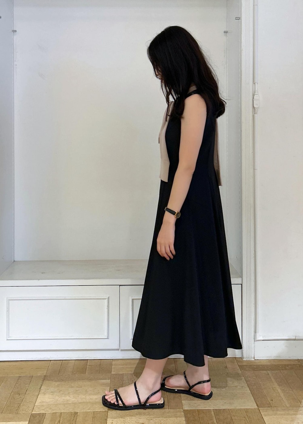 ブラック系のドレス、ブラック系のショルダーバッグ、ベージュ系のカーディガン/ボレロを着用したレディースの夏コーディネートの3枚目の写真