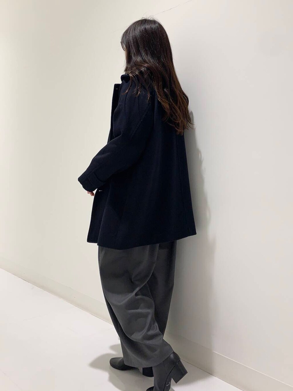 ブラック系のブーツ、ブラック系のハンドバッグ、グレー系のその他パンツを着用したレディースの冬コーディネートの2枚目の写真