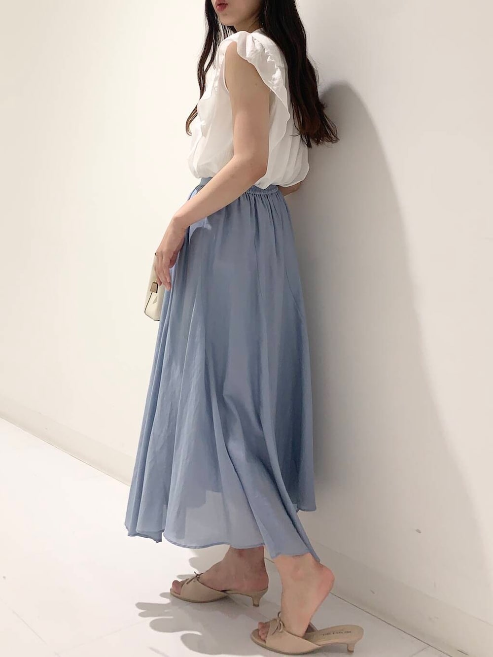 ホワイト系のハンドバッグ、ホワイト系のカーディガン/ボレロ、ベージュ系のサンダルを着用したレディースの夏コーディネートの5枚目の写真