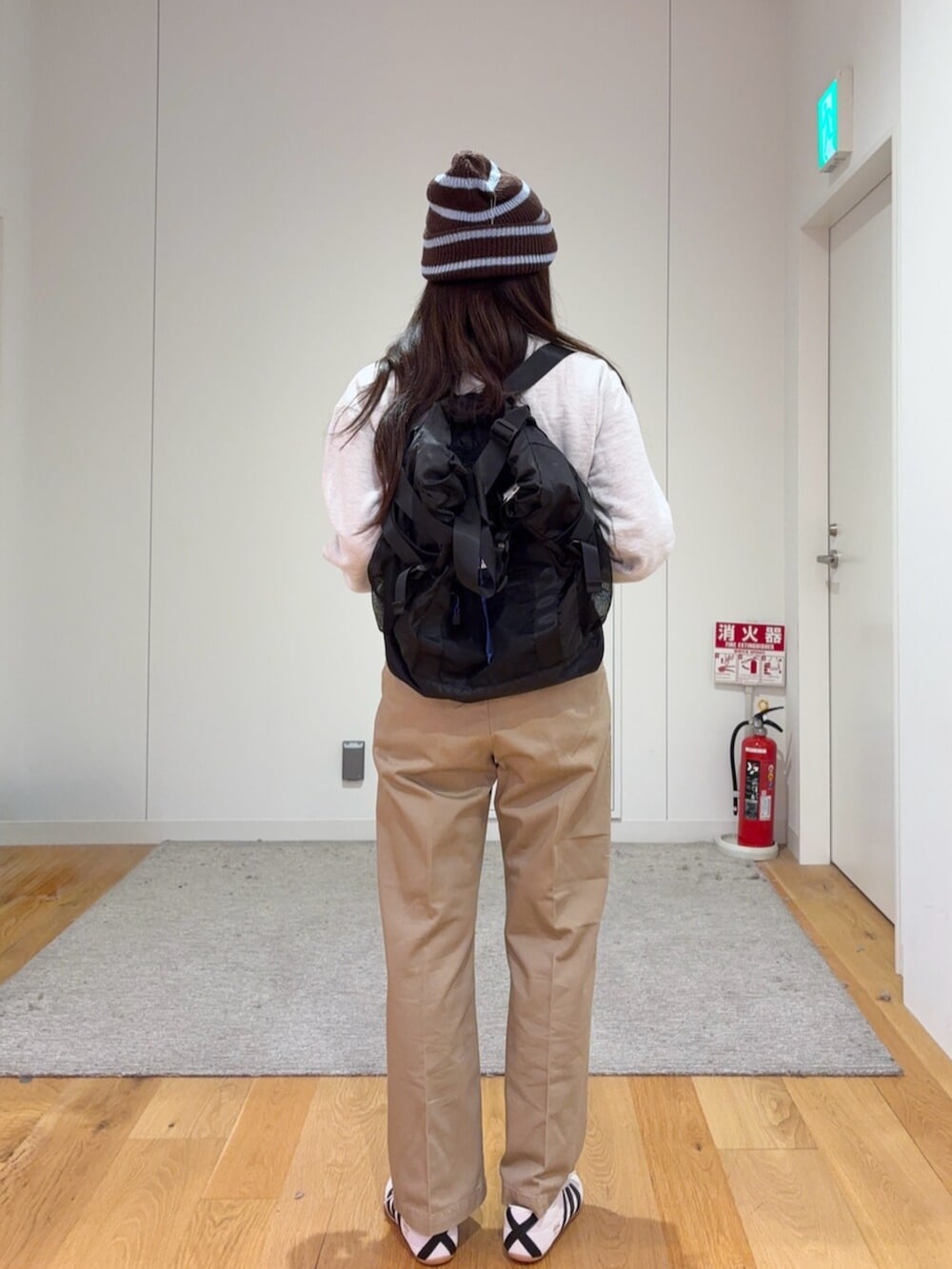 グレー系のダウンベスト、ベージュ系のその他パンツ、ブラック系のトートバッグを着用したレディースの秋コーディネートの5枚目の写真