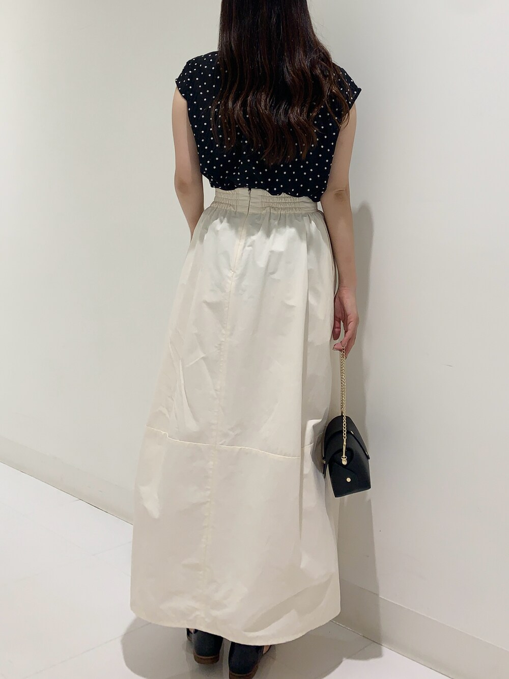 ブラック系のシャツ/ブラウス、ホワイト系のスカート、ブラック系のショルダーバッグを着用したレディースの夏コーディネートの3枚目の写真