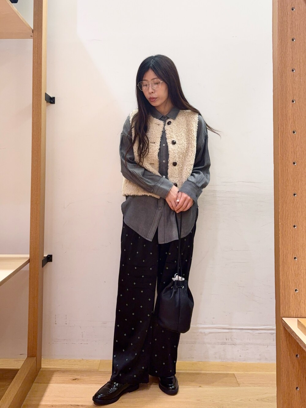 ベージュ系のダウンベスト、グレー系のシャツ/ブラウス、ブラック系のその他パンツを着用したレディースの秋コーディネートの3枚目の写真