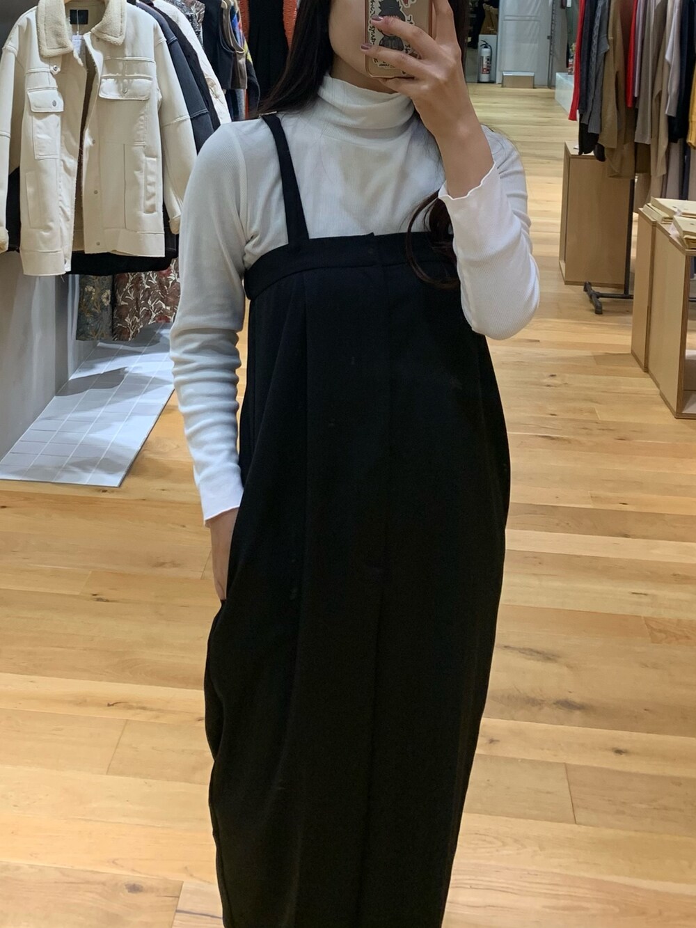 ホワイト系のTシャツ/カットソー、ベージュ系のカーディガン/ボレロ、ブラック系のサロペット/オーバーオールを着用したレディースの秋コーディネートの7枚目の写真