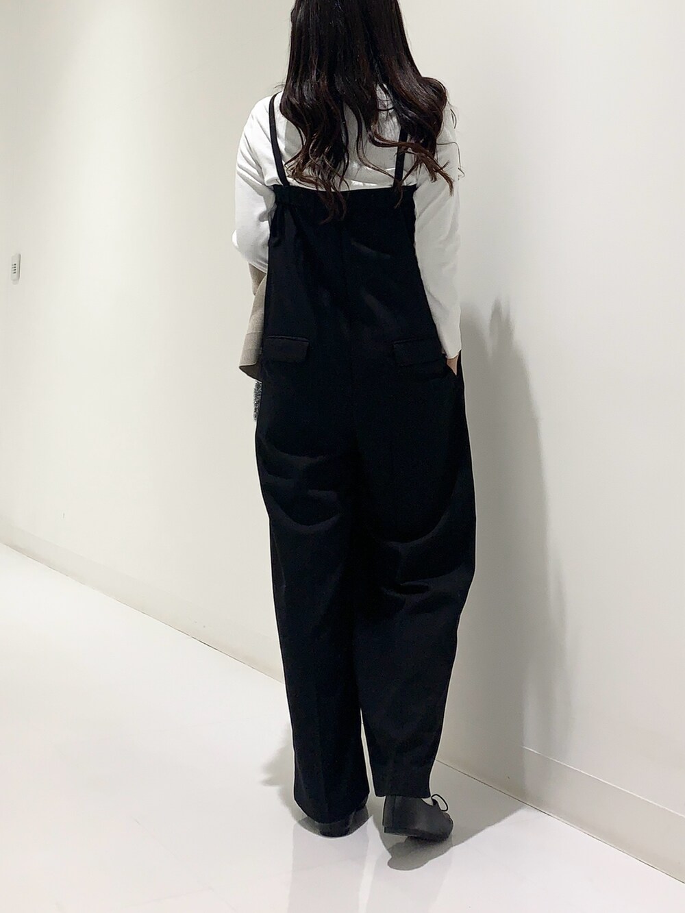 ホワイト系のTシャツ/カットソー、ベージュ系のカーディガン/ボレロ、ブラック系のサロペット/オーバーオールを着用したレディースの秋コーディネートの6枚目の写真