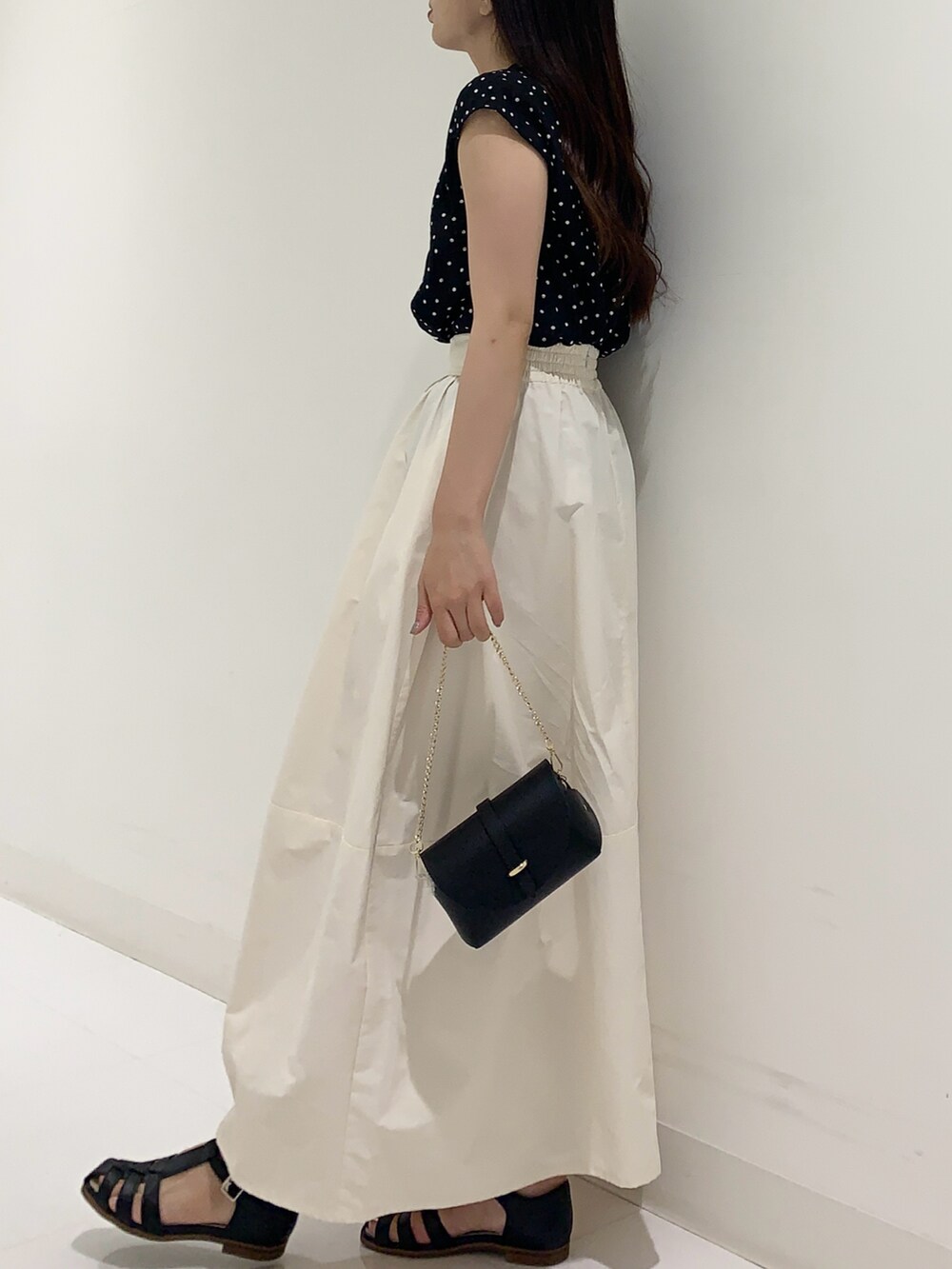 ブラック系のシャツ/ブラウス、ホワイト系のスカート、ブラック系のショルダーバッグを着用したレディースの夏コーディネートの2枚目の写真