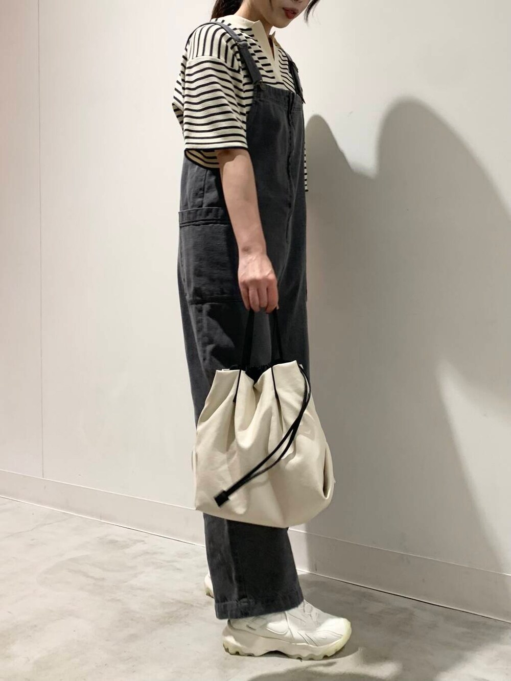 ホワイト系のショルダーバッグ、ホワイト系のスニーカー、ホワイト系のニット/セーターを着用したレディースの夏コーディネートの2枚目の写真