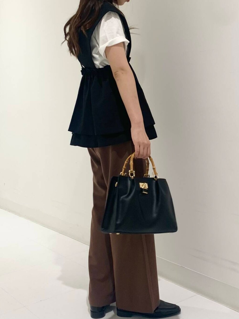 ホワイト系のTシャツ/カットソー、ブラック系のハンドバッグ、ブラック系のローファーを着用したレディースの夏コーディネートの4枚目の写真