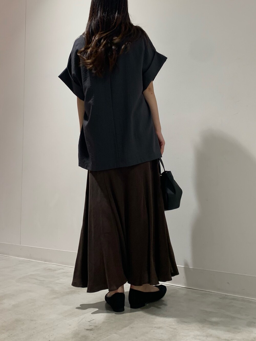 グレー系のテーラードジャケット、ブラウン系のスカート、ホワイト系のTシャツ/カットソーを着用したレディースの夏コーディネートの3枚目の写真