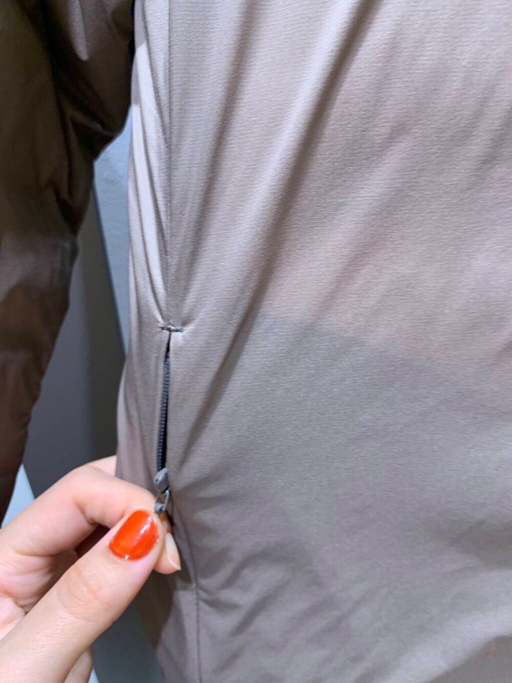 ブラウン系のダウンジャケット/コート、ブラック系のブーツ、ホワイト系のパーカーを着用したレディースの秋コーディネートの5枚目の写真