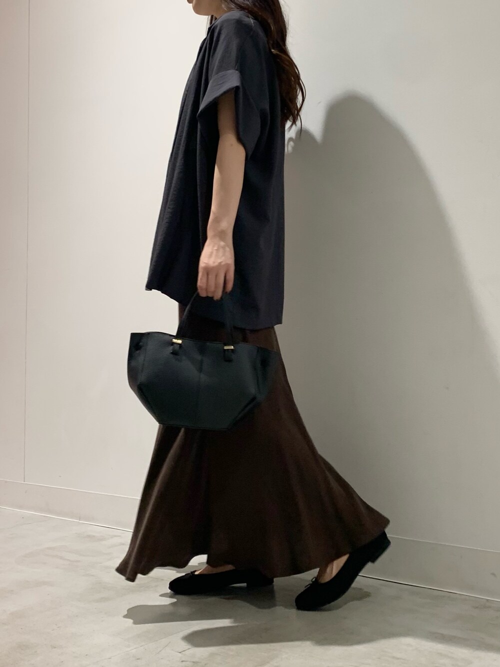 グレー系のテーラードジャケット、ブラウン系のスカート、ホワイト系のTシャツ/カットソーを着用したレディースの夏コーディネートの2枚目の写真