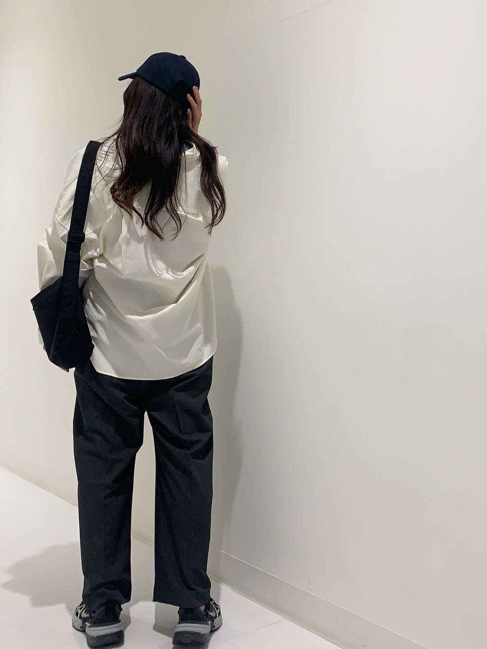 ブルー系のニット/セーター、ホワイト系のシャツ/ブラウス、グレー系のサロペット/オーバーオールを着用したレディースの冬コーディネートの3枚目の写真