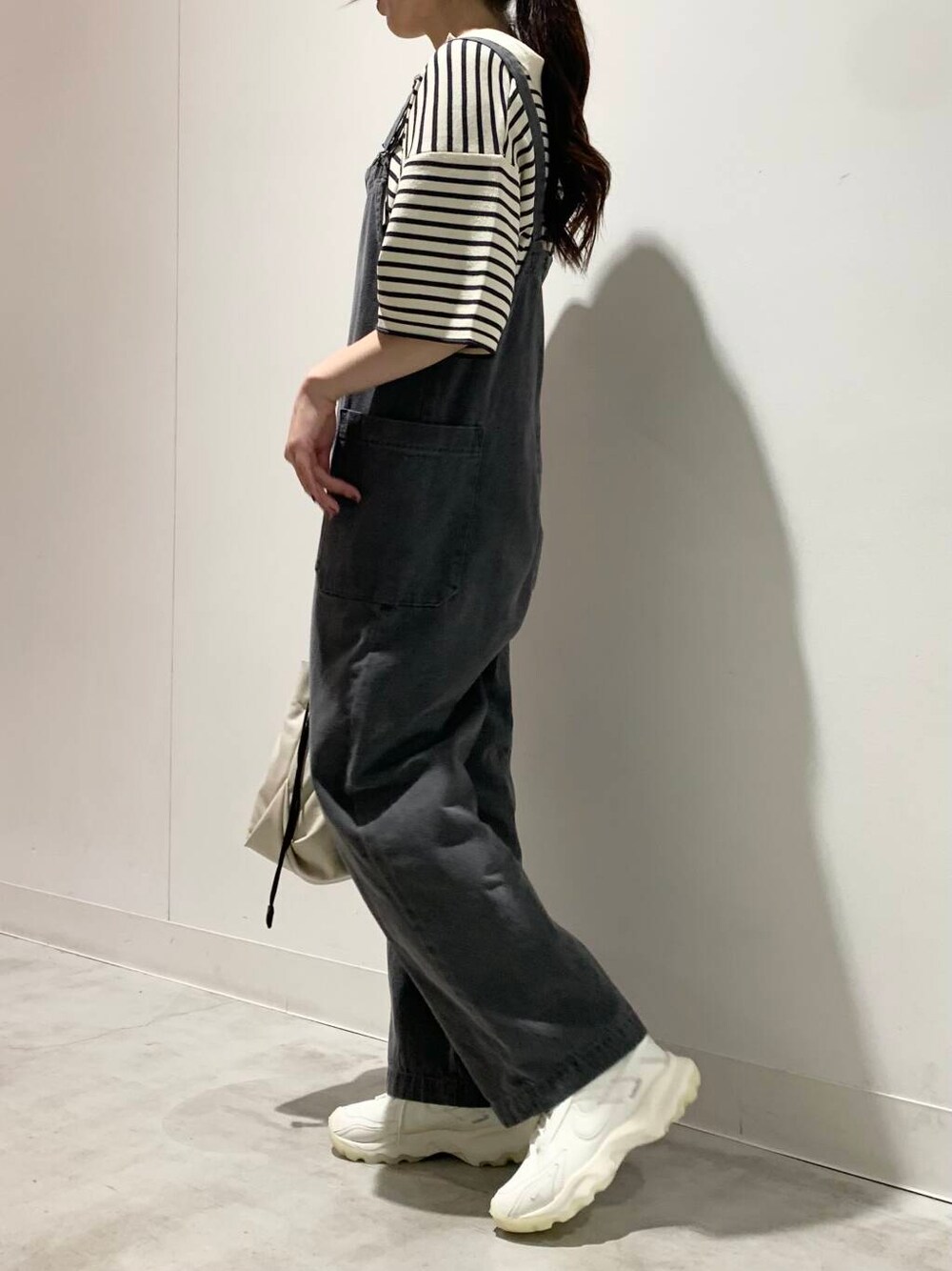 ホワイト系のショルダーバッグ、ホワイト系のスニーカー、ホワイト系のニット/セーターを着用したレディースの夏コーディネートの4枚目の写真