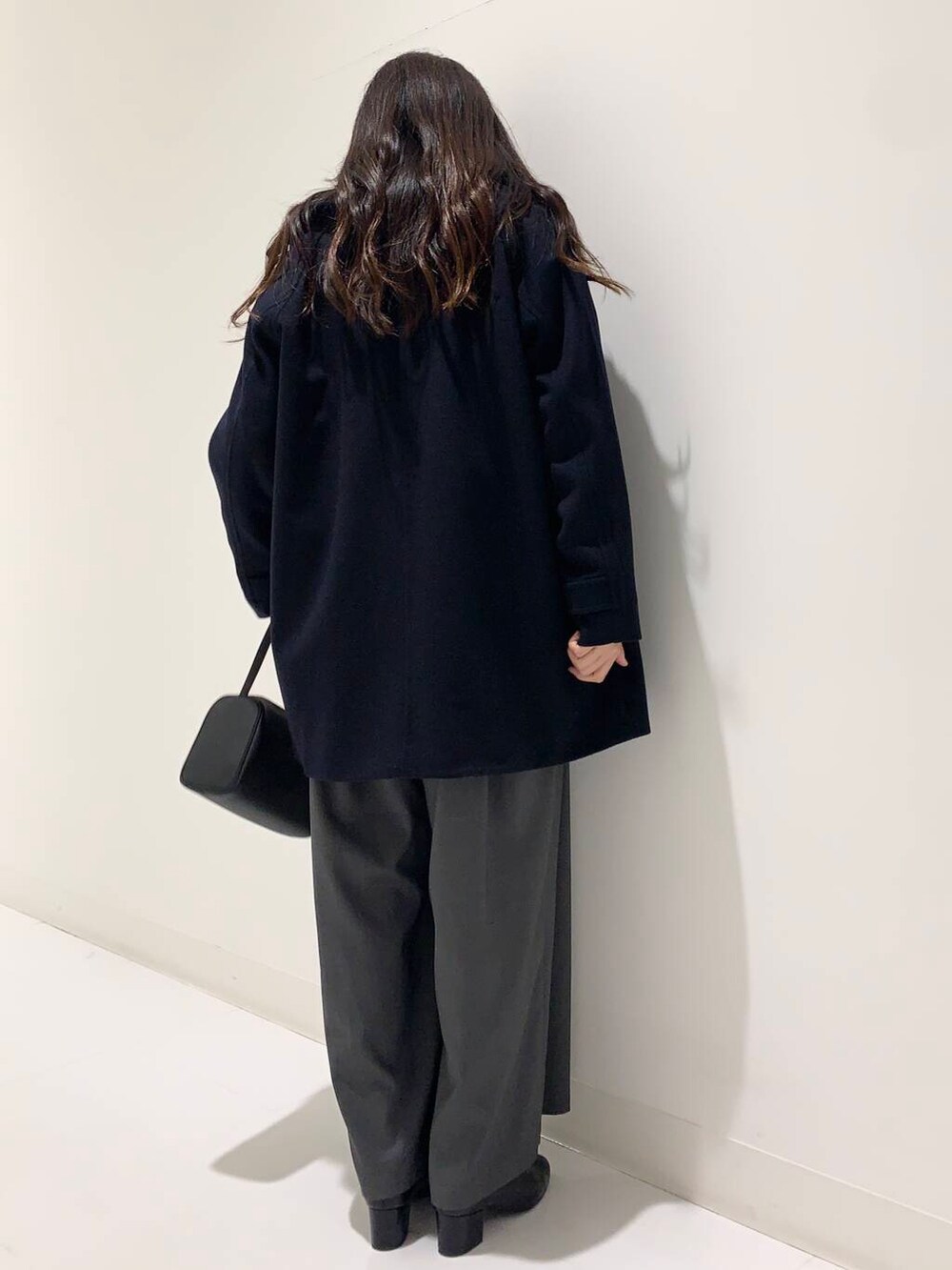 ブラック系のブーツ、ブラック系のハンドバッグ、グレー系のその他パンツを着用したレディースの冬コーディネートの3枚目の写真