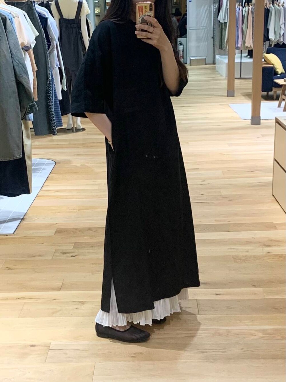 ブラック系のワンピース、ホワイト系のハンドバッグ、ブラック系のバレエシューズを着用したレディースの春コーディネートの4枚目の写真