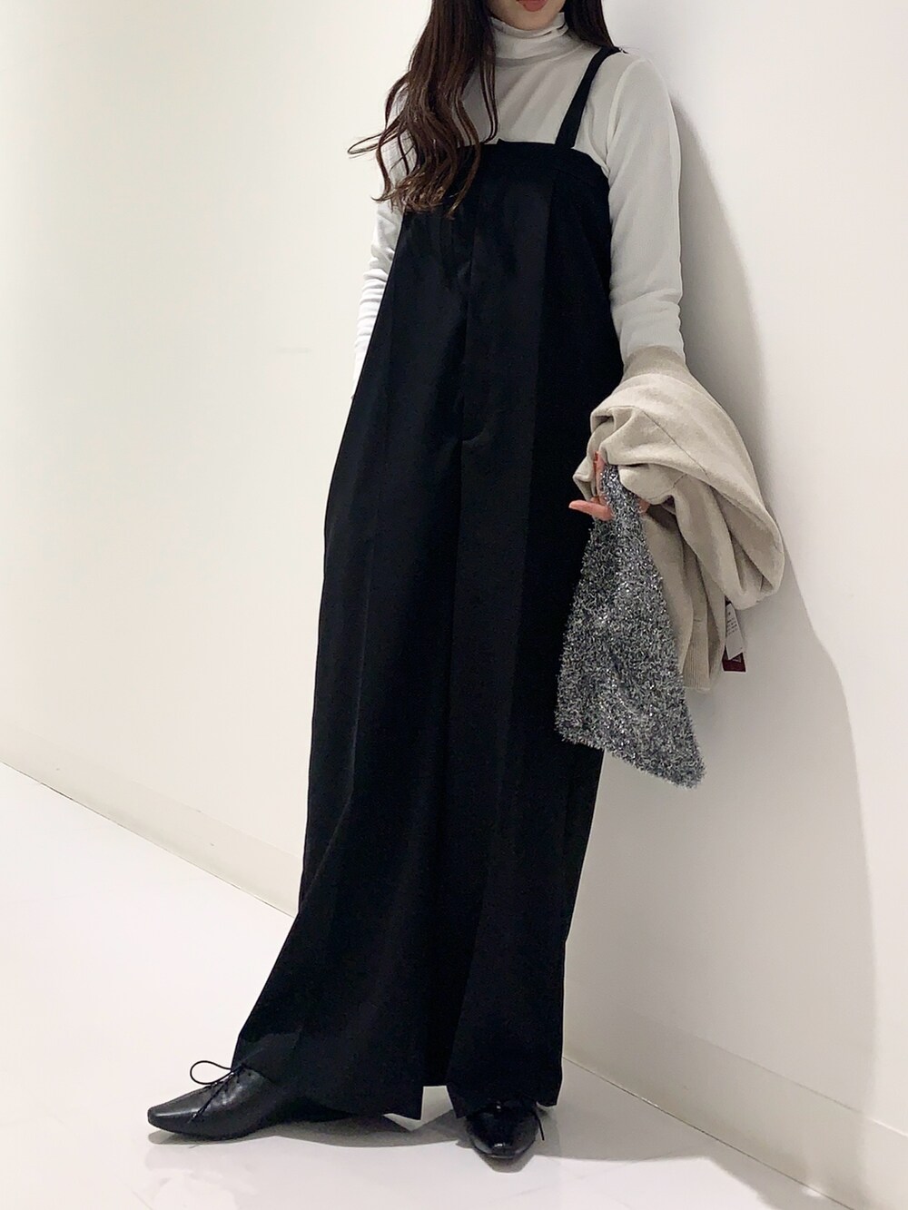 ホワイト系のTシャツ/カットソー、ベージュ系のカーディガン/ボレロ、ブラック系のサロペット/オーバーオールを着用したレディースの秋コーディネートの4枚目の写真