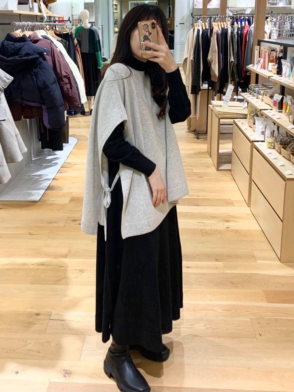 ブラック系のステンカラーコート、ブラック系のブーツ、ブラック系のショルダーバッグを着用したレディースの冬コーディネートの8枚目の写真