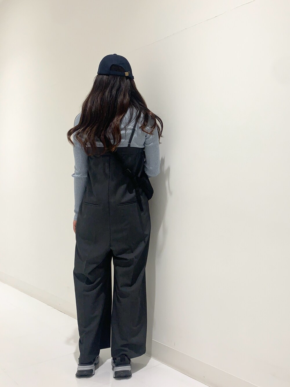 ブルー系のニット/セーター、ホワイト系のシャツ/ブラウス、グレー系のサロペット/オーバーオールを着用したレディースの冬コーディネートの6枚目の写真