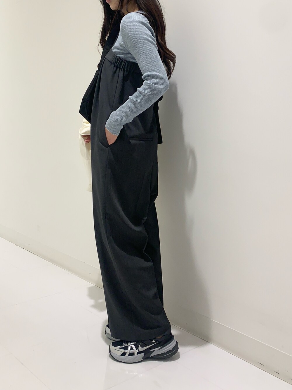 ブルー系のニット/セーター、ホワイト系のシャツ/ブラウス、グレー系のサロペット/オーバーオールを着用したレディースの冬コーディネートの5枚目の写真