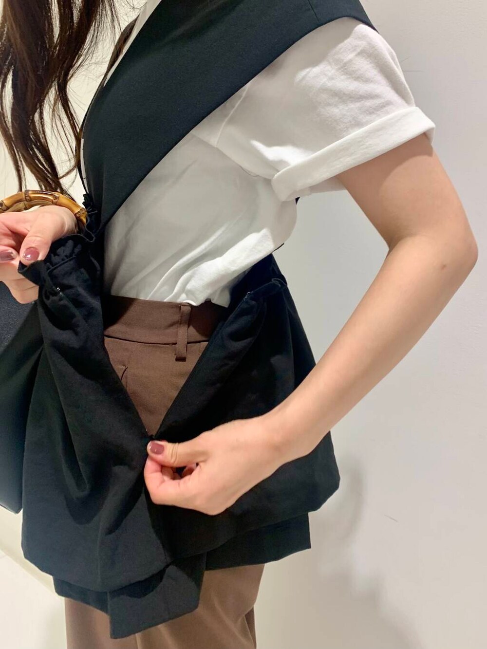 ホワイト系のTシャツ/カットソー、ブラック系のハンドバッグ、ブラック系のローファーを着用したレディースの夏コーディネートの5枚目の写真