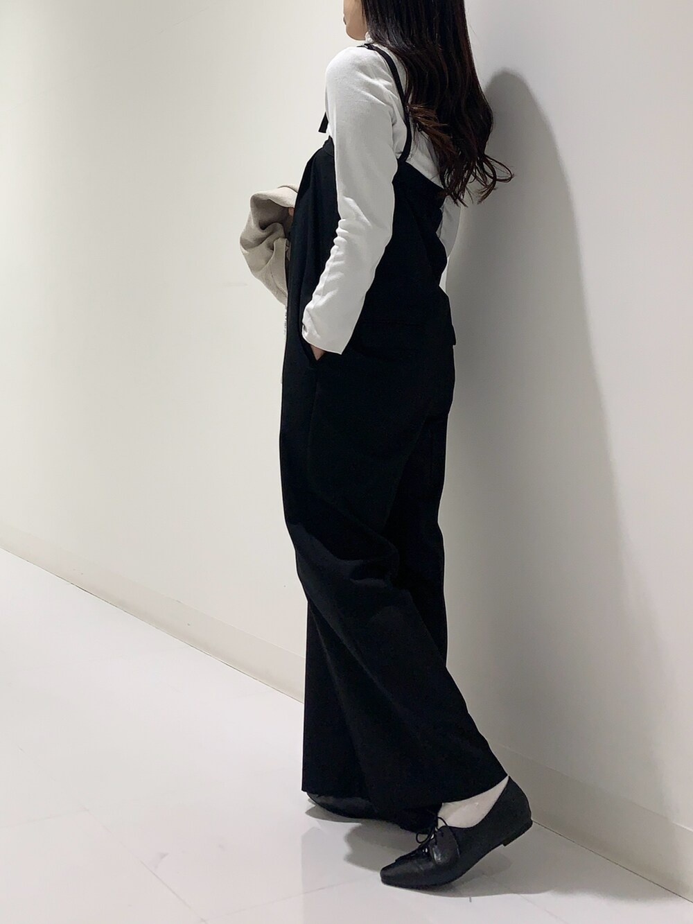 ホワイト系のTシャツ/カットソー、ベージュ系のカーディガン/ボレロ、ブラック系のサロペット/オーバーオールを着用したレディースの秋コーディネートの5枚目の写真