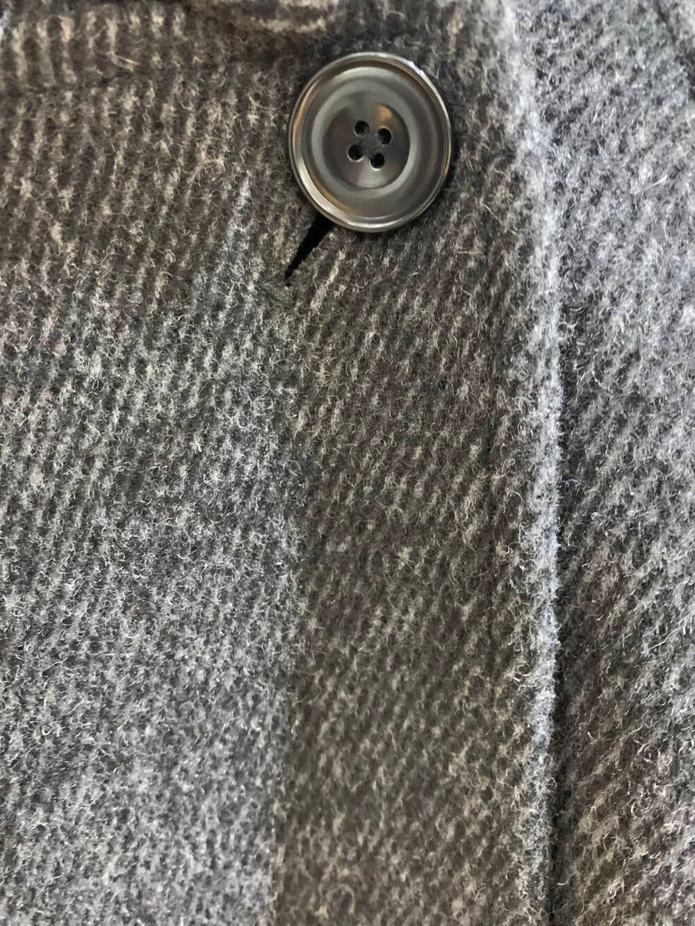 ブラック系のステンカラーコート、ブラック系のブーツ、ブラック系のショルダーバッグを着用したレディースの冬コーディネートの7枚目の写真