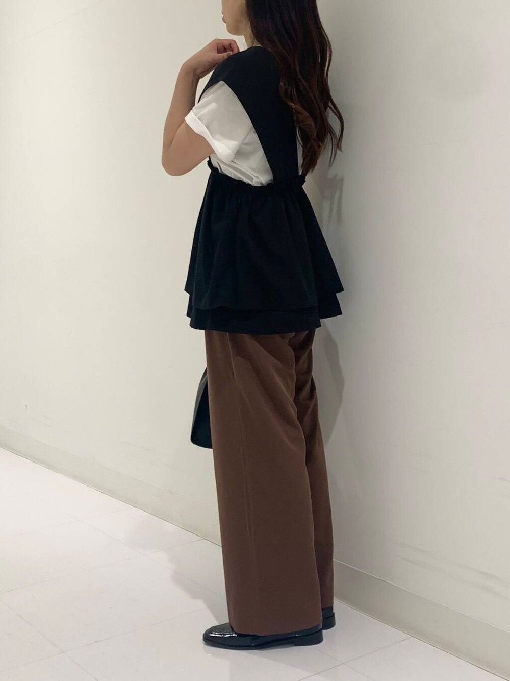 ホワイト系のTシャツ/カットソー、ブラック系のハンドバッグ、ブラック系のローファーを着用したレディースの夏コーディネートの2枚目の写真